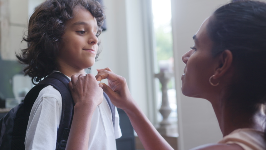 Slow motion of mother helping son get ready for school