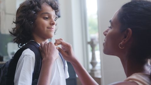 Slow motion of mother helping son get ready for school Video Stok