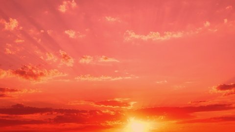 Amazing Red Sunset in a Colorful Bright Sky with Light Clouds, Timelapse. Sun Beautifully Sets Over the Horizon Illuminating a Pink Orange Red Sky with Clouds. Unusual Sunset.