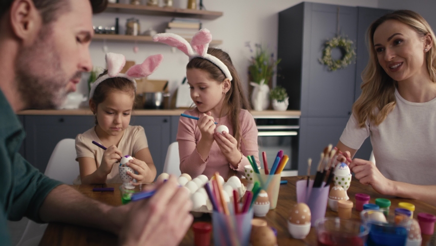 Caucasian family of four people chatting and decorating easter eggs at home. Shot with RED helium camera in 8K | Shutterstock HD Video #1087137758