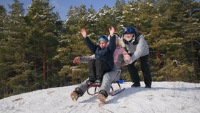 grandparents have fun together with their grandson in a snowy forest in winter, boy child with a grandmother raise their hands and slide down a hill on a sled - Powered by Shutterstock - Get 15% off with code: PIKWIZARD15