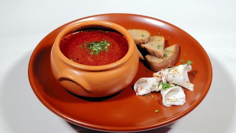 Ukrainian national traditional dish borsch. Ready red beet soup with pieces of lard and bread with garlic.