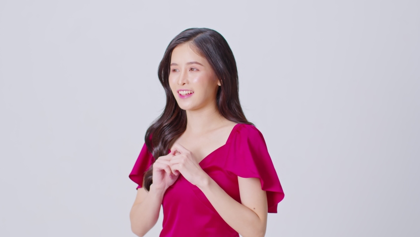 Happy attractive asian young woman excited surprised open mouth and touching her cheer on white background.Amaze cheerful pretty girl wear red dress looking at camera smile and laughing.Good moment