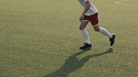 Close up of a soccer player receiving a pass and shooting the ball towards the goal on a soccer field. Soccer players are wearing unbranded sports clothes. 4k slow motion video.