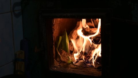 kindling firewood in the oven. firewood is burning in the home fireplace.