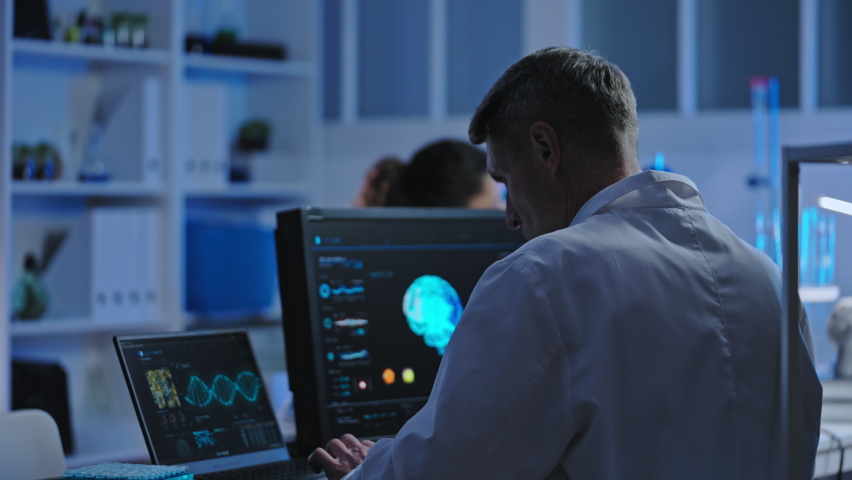 Scientist conducting genetic research in laboratory, using computer technology