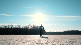 Silhouette of a man walking into the distance through the snow during sunset. A loner walks across a large meadow of snow. Failure and loneliness. - Powered by Shutterstock - Get 15% off with code: PIKWIZARD15