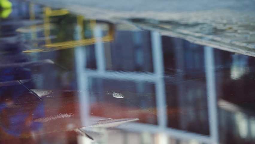 Female sports woman jogging outdoors, stepping into puddle. Single runner running in rain, making splash. Slow motion