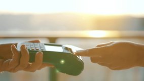 NFC credit card payment. Woman paying with contactless credit card with NFC technology. Wireless money transaction. Card machine in male hand on sunlight background - Powered by Shutterstock - Get 15% off with code: PIKWIZARD15
