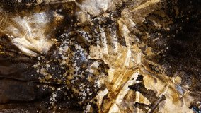 Gold foil and paint splatter moving slowly on a rusted brown background. - Powered by Shutterstock - Get 15% off with code: PIKWIZARD15