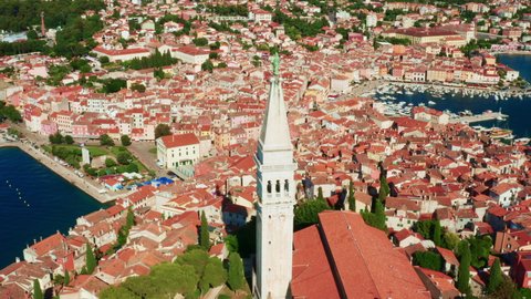 Church of St. Euphemia against small houses with red rooftops in Croatian city Rovinj. Architecture of old European town located near Adriatic sea. Aerial view