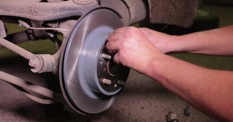 Changing brake rotor disc on a car in the garage