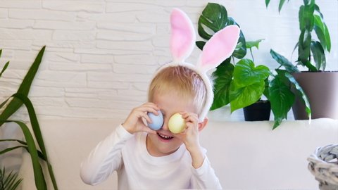 Funny happy child boy with easter eggs and bunny ears dancing. Easter concept, happy childhood. Easter Egg Hunt. Slow motion.