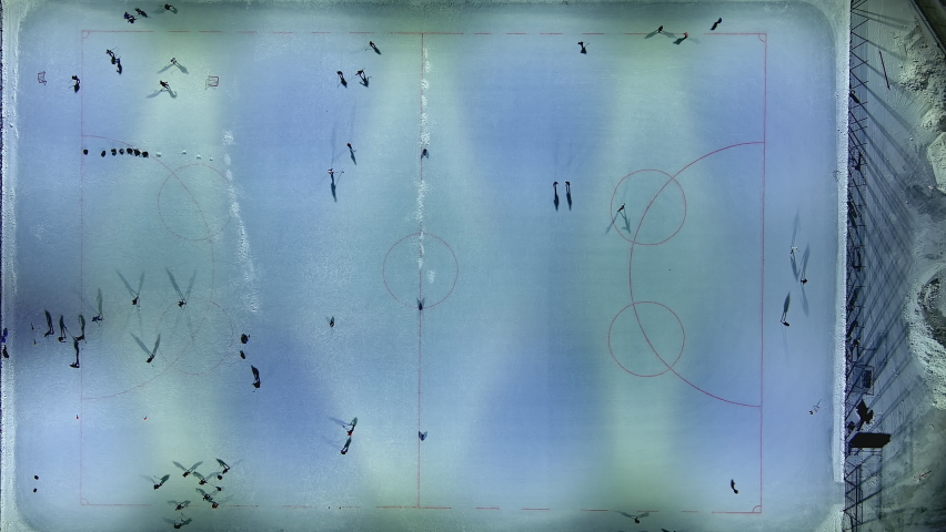 Helsinki.Finland-January 18.2022: Aerial shot of a skating rink in Helsinki Finland. People enjoying the winter activities. Nighttime. Camera pointing downwards while the drone is moving upwards.