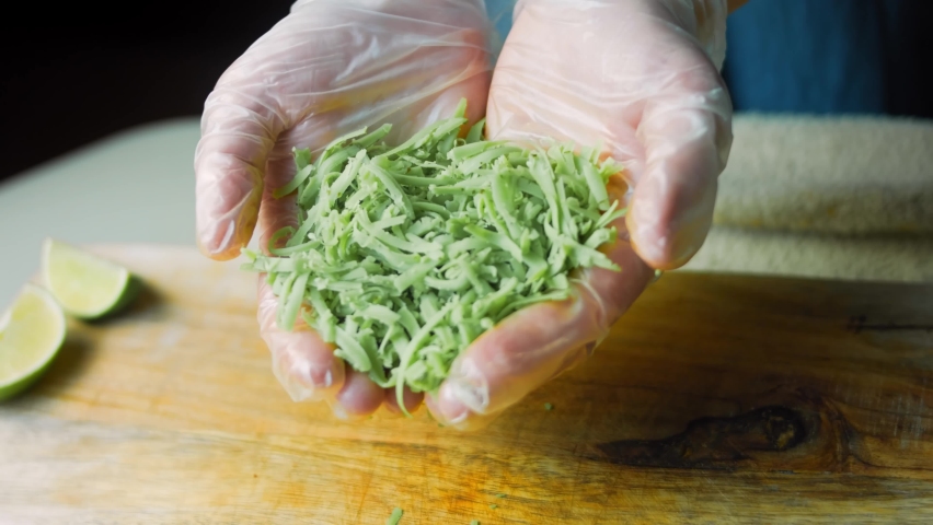 I hold in my hands a green pesto cheese cut into small pieces