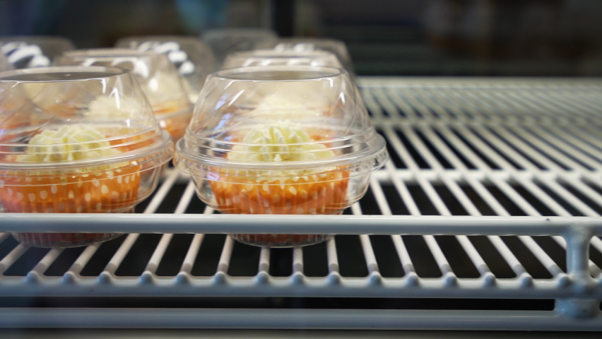 Individually packaged vanilla cupcakes in case, slider 4K