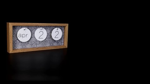 A wooden calendar block showing the date April 21st  the H.M. The Queen’s Birthday with a mans hand putting on and taking off the metal discs with the date and month on them, filmed in 8k quality.