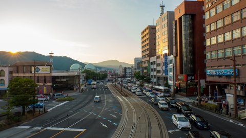 NAGASAKI, JAPAN - 28 JULY 2018: Aerial view of lively center in Nagasaki, Japan in the evening car and people traffic. Time-lapse during the sunset