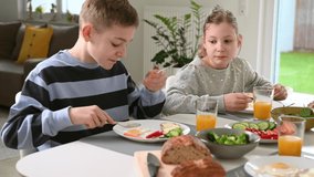 4K video of teen children having healthy breakfast at home in the morning 