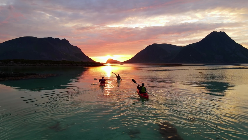Aerial drone view following kayaks, paddling towards mountains and the sunset in Lofoten, Norway Royalty-Free Stock Footage #1087180745