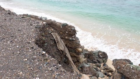 Ocean sea wall sustained major damage due to rising tides and waves causing corrosion, washing away, impacts of climate change, pan left to right