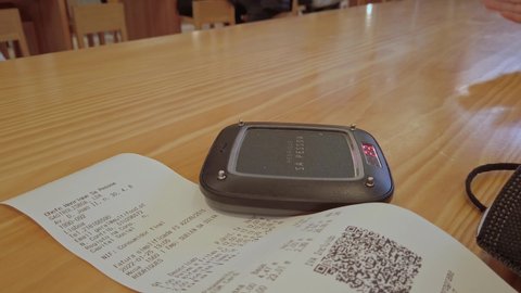 Lisbon , Portugal - 01 25 2022: Food Pager Buzzer Resting On Receipt With QR Code On Table. Close Up