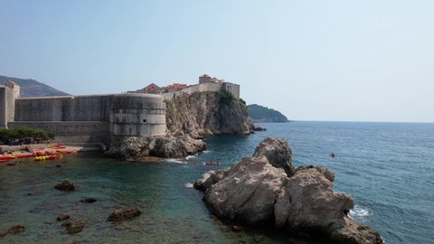 Aerial Approach and Pass By Fortified Stone Sea Walls of Dubrovnik Croatia Medieval Venetian Coastal City in Adriatic on Hazy Summer Day Drone 4k