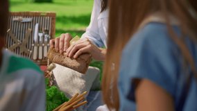 Careful mother share tasty sandwich between children on park picnic close up. Beautiful smiling mother feeding hungry kids on green lawn on sunny day. Happy family eat delicious snacks on nature. - Powered by Shutterstock - Get 15% off with code: PIKWIZARD15