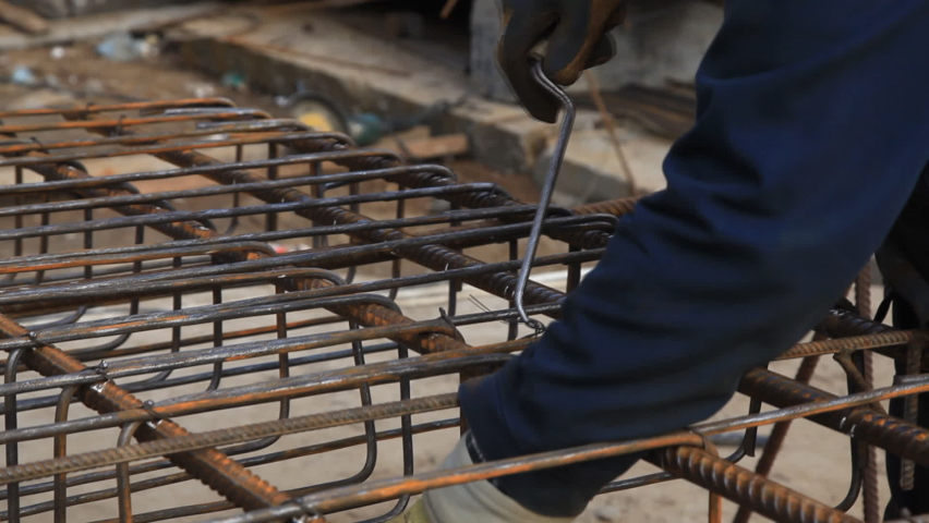 Worker connects wire metal structures. Steel Fixers Connecting Steel Rods for Concrete Reinforcement Royalty-Free Stock Footage #1087188887