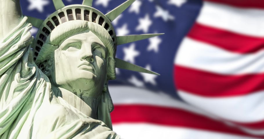 the statue of liberty with blurred american flag waving in the background. Democracy and freedom concept.