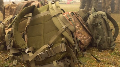 Lying camouflage-colored backpacks on the grass close-up.Military exercises.