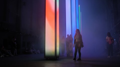 NIZHNY NOVGOROD, RUSSIA - AUGUST 27, 2021: Digital Festival. People looking at interactive LED wall show on columns, light beams and fog. Sightseeing, futuristic and contemporary art concept