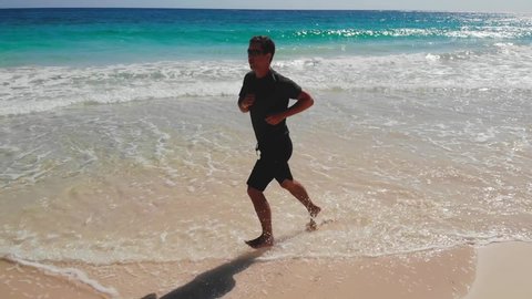 Man before running do training at beach sunrise. Young man running barefoot on beach exercising male runner sprinting training in morning seaside background dawn.Man Run. Man Runner. Healthy lifestyle