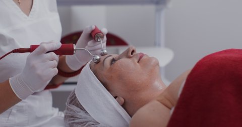 The procedure for the treatment and rejuvenation of facial skin with a new generation laser device. The patient is undergoing facial skin treatment in a modern clinic. Video in 4k, red komodo