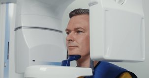 Panoramic X-ray filming of the patient's jaw on diagnostic equipment. Orthopantomography device for teeth, MRI, modern dental clinic. Video in 4k, red komodo