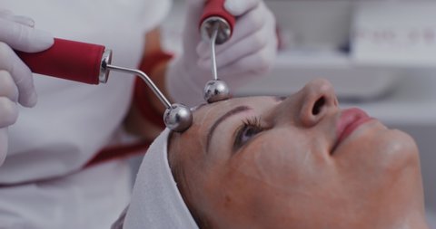 The patient undergoes facial skin treatment in a modern clinic using a laser, close-up. Getting rid of mimic wrinkles with the help of modern equipment. Video in 4k, red komodo