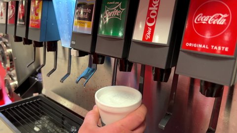 DAYTON, OHIO, USA - JANUARY 9: Filling cup of sprite drink at soda fountain where customers self serve for unlimited drink refills in restaurant Dayton, Ohio on January 9, 2022.