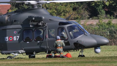 Thiene Italy, OCTOBER, 16, 2021 Military search and rescue helicopter takes off backwards from a meadow after having dropped the rescuer with the stretcher. Agusta Westland AW139 of Italian Air Force