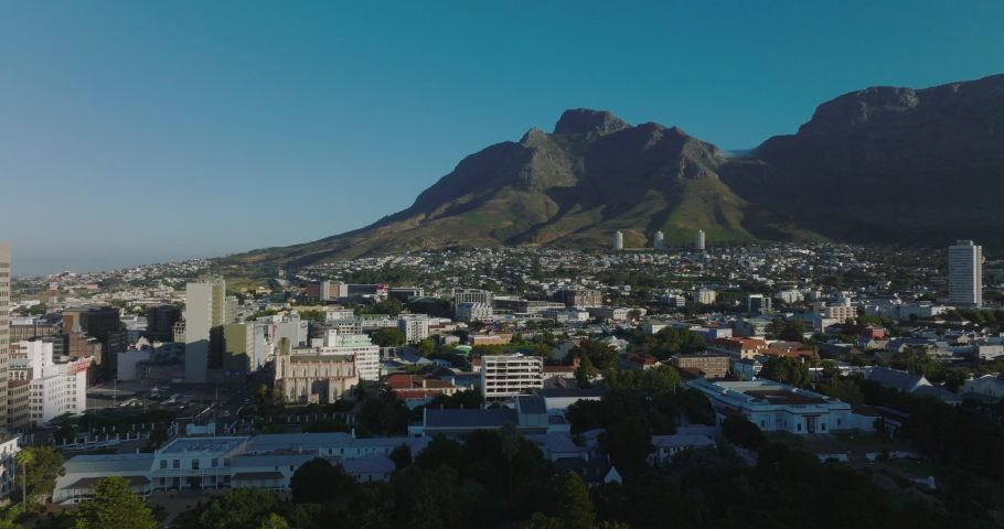 Residential borough and rocky peaks in Table Mountain National Park. Forwards fly above urban neighbourhood. Cape Town, South Africa