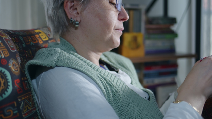 Young Woman Knits with Colorful balls of Wool and Needles