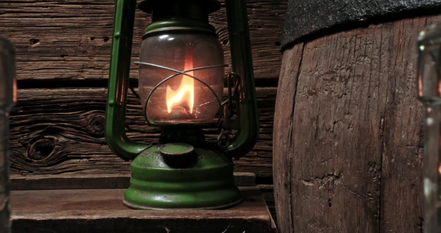 Glass of whisky in distillery warehouse. Handcrafted cognac in the old warehouse basement. Parallax effect