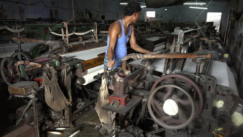 Indian man working at Weaving Machine In Textile Production, Weaving Loom, Bhiwandi, Mumbai, India, Circa 2021