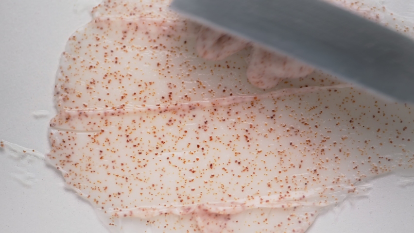 Spreading natural pink body scrub with metal spatula over white table upper close view. Homemade skincare product for beauty Royalty-Free Stock Footage #1087253024