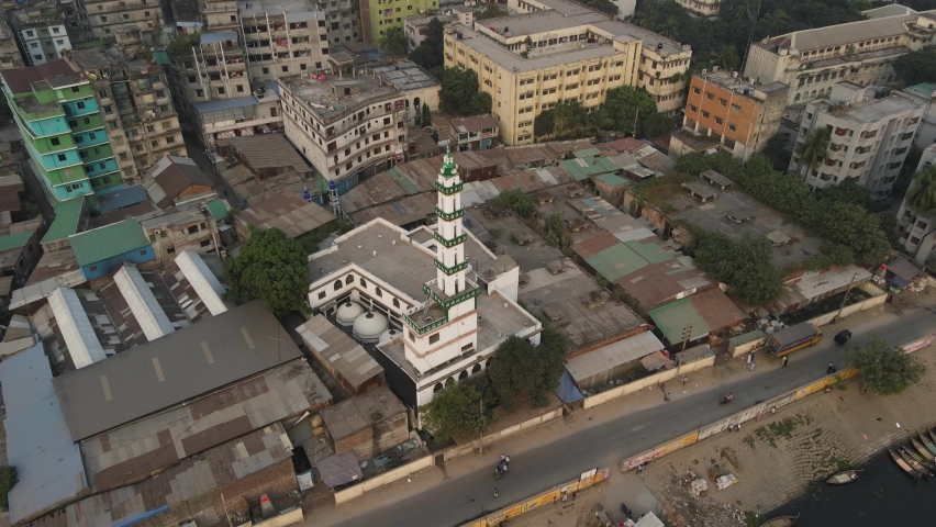 Aerial: top view of a mosque minaret in Dhaka slum area - drone flight shot