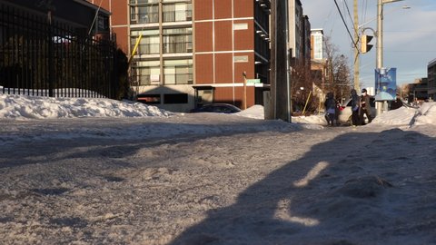 Waterloo, Ontario, Canada February 2022 People walking on ciy slippery city sidewalk after winter ice and snow storm