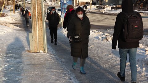 Waterloo, Ontario, Canada February 2022 People walking on ciy slippery city sidewalk after winter ice and snow storm