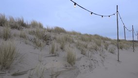 Dunes with fairy lights on a windy day at the beach