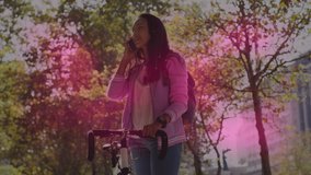 Animation of shapes moving over asian woman using smartphone with bicycle. pedal day and celebration concept digitally generated video.
