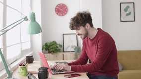 Young hipster adult man working on laptop computer from home office. High quality 4k footage