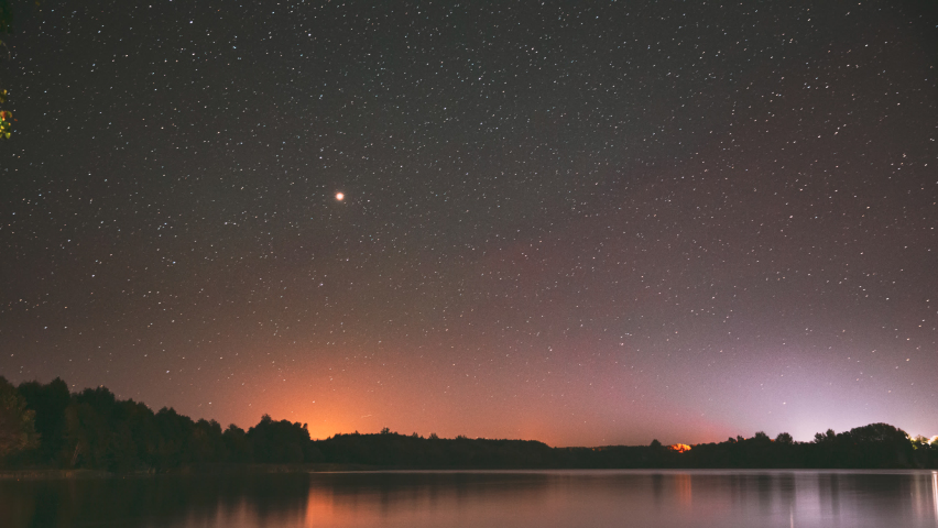 Lyepyel District, Vitebsk Province, Belarus. Real Colorful Night Stars Above Lepel Lake. Natural Starry Sky Background Backdrop Landscape. Time lapse. 4K.
